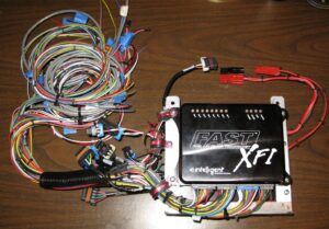 The attached is a picture of the FAST XFI computer and ignition box assembly with all of the wiring that could be done off the car (power circuits, grounds, relays, fuses, etc). As you can see, there were still quite a few wires left to connect.